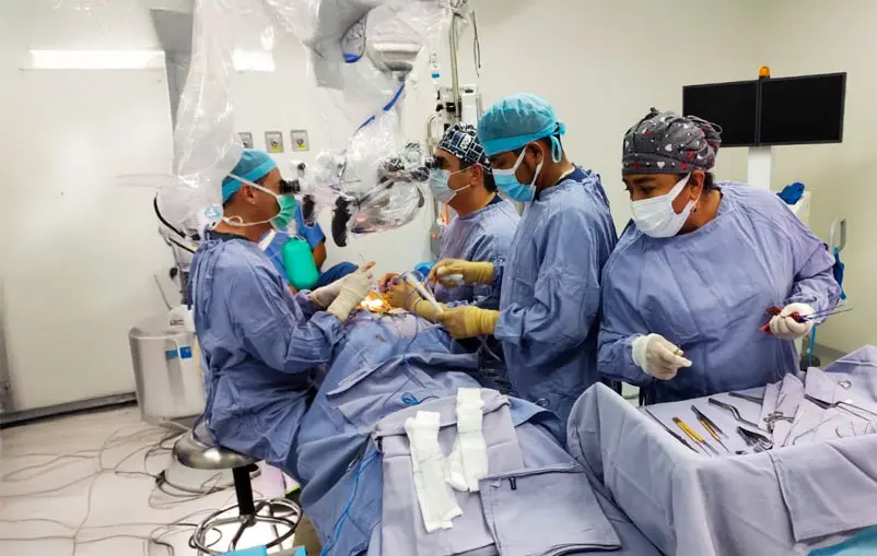Multiple neurosurgeons in operating room conducting a high-precision pediatric procedure